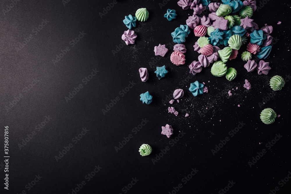 Colored meringue with crumbs on black background Colored meringue with crumbs on black background