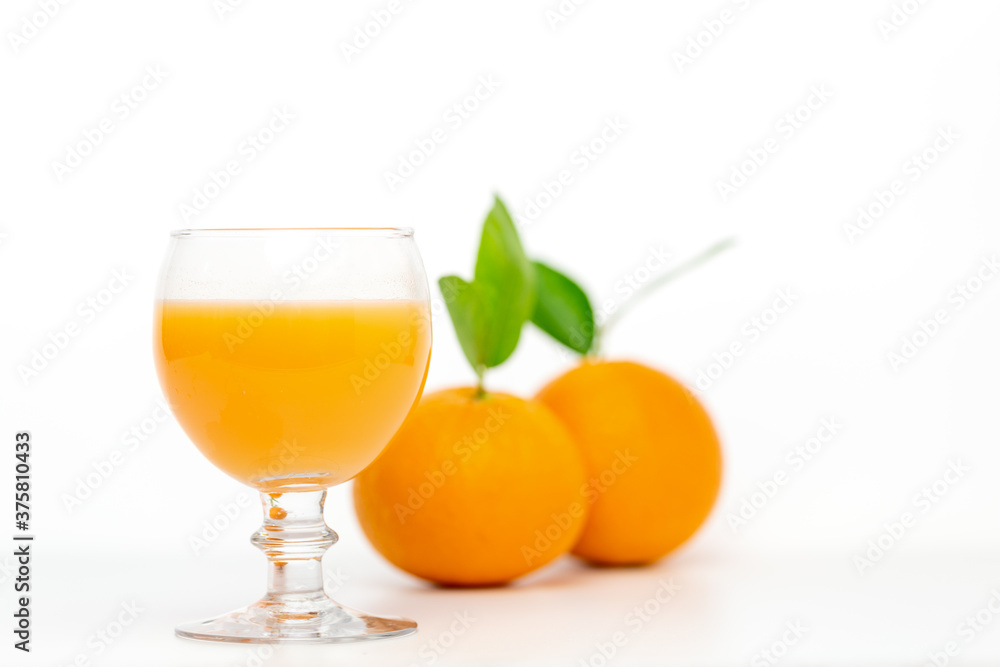 Orange juice in glass and fresh orange fruit on white background.