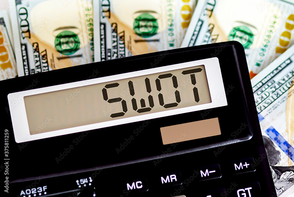 Calculator with text SWOT on the dollars. Business, finance conceptual. Calculator with text SWOT on the dollars. Business, finance conceptual.