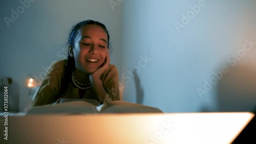Niña disfrutando de la lectura tumbada en la cama