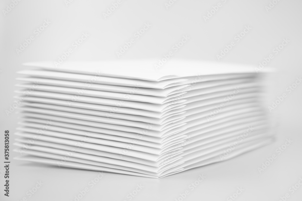 Stack of paper envelopes on white background. A pile of DVDs and CDs in white envelopes. Office supplies Stack of paper envelopes on white background. A pile of DVDs and CDs in white envelopes. Office supplies