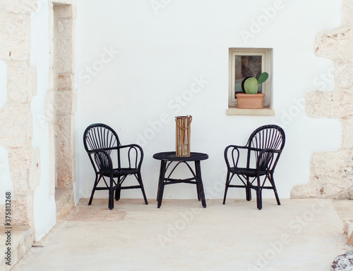 Black table and chairs near a wall in a garden photo