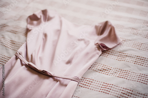 Silk pink bridesmaid wedding dress on bed photo
