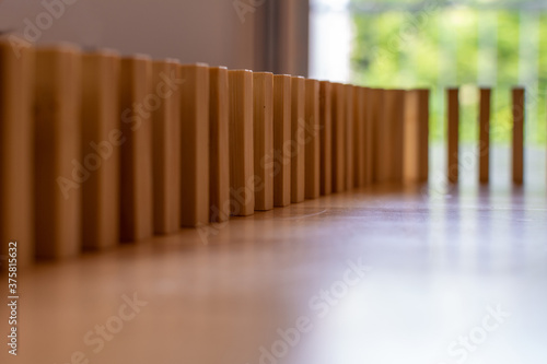 Wooden block domino standing stable on wood table  business chain and connection symbol  domino effect theory