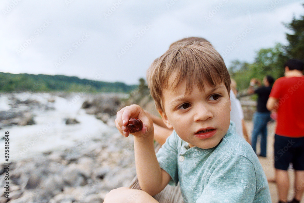 LIttle guy eating cherries while taking in the sights at Great Falls, Maryland LIttle guy eating cherries while taking in the sights at Great Falls, Maryland
