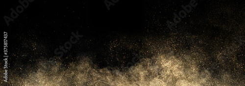Gold glitter powder splash on black background photo