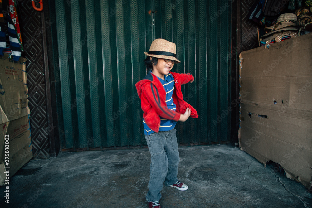 Young kid with hat dancing and having fun in front of a closed store Young kid with hat dancing and having fun in front of a closed store