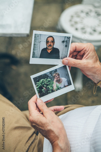 Senior couple looking at polaroid photos of themselves