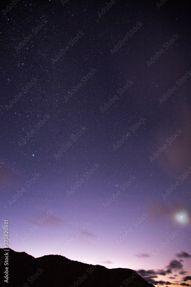 Purple night sky with bright star and mountains Purple night sky with bright star and mountains