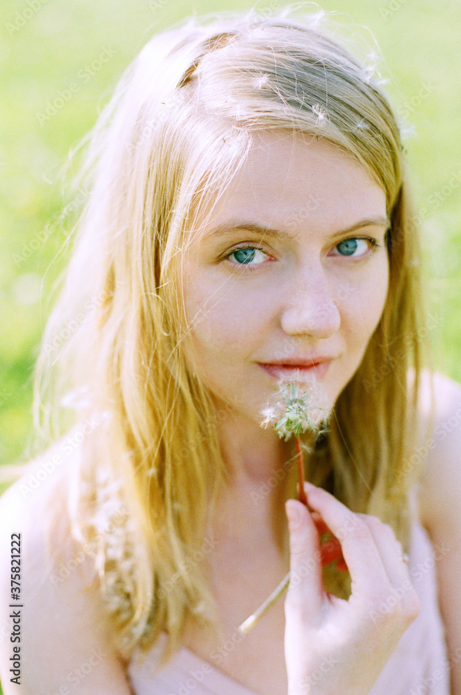 Portrait of blonde woman with dandelion Portrait of blonde woman with dandelion