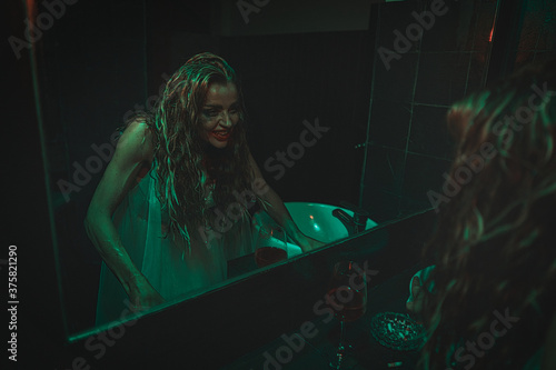 Obraz na płótnie mysterious woman wearing wedding dress looking at her scary reflection in a mirror. w salonie
