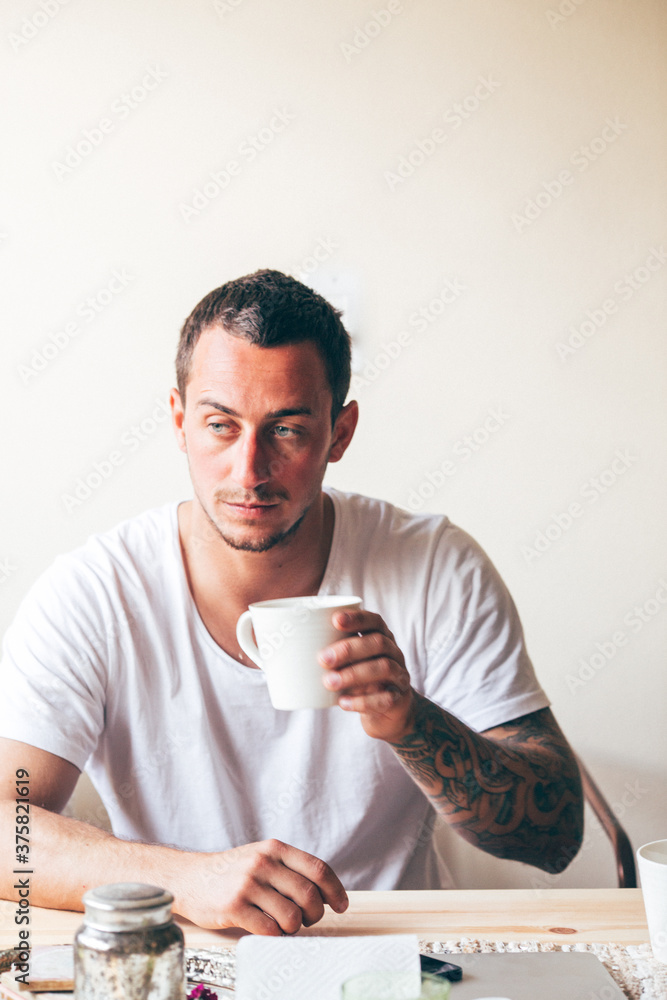 Young man drinking a morning cup of coffee indoors Young man drinking a morning cup of coffee indoors