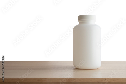 Medicine bottle on wood table isolated on white background