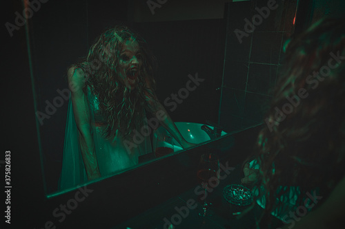 Obraz na płótnie mysterious woman wearing wedding dress looking at her scary reflection in a mirror. w salonie