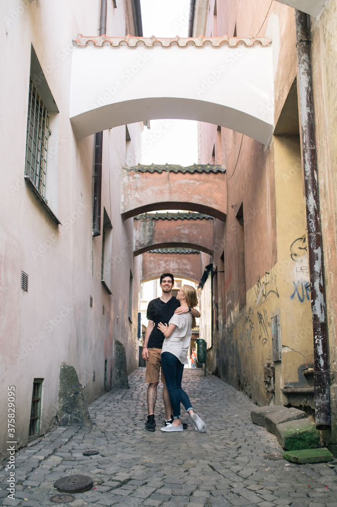 Young couple in the tiny street in the city Young couple in the tiny street in the city