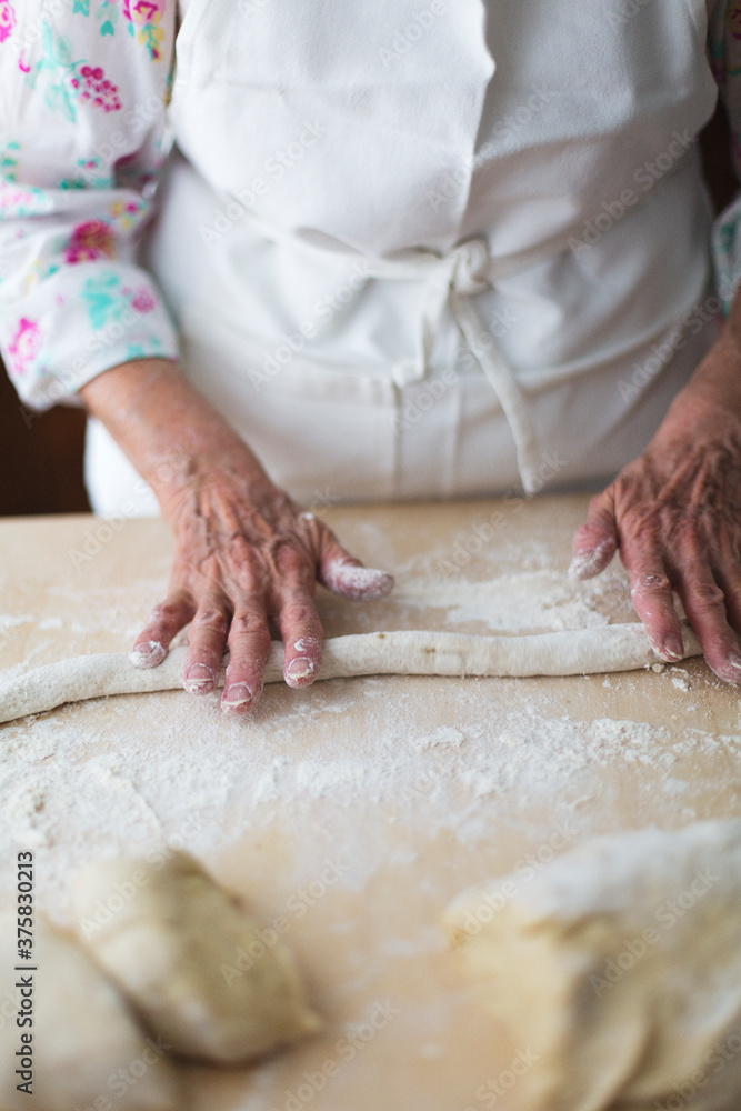 Cooker giving shape to dough while making gnocchi Cooker giving shape to dough while making gnocchi