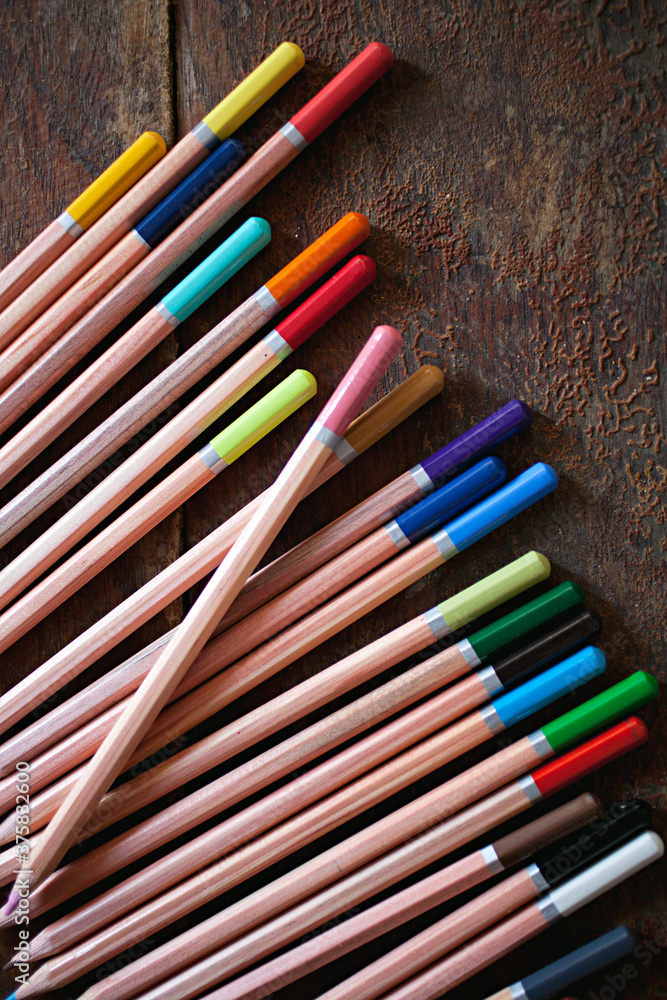 almost new coloured pencils on a wooden table background almost new coloured pencils on a wooden table background