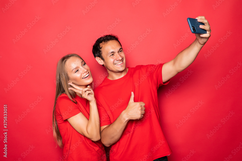 Young couple take selfie on phone isolated on red background Young couple take selfie on phone isolated on red background