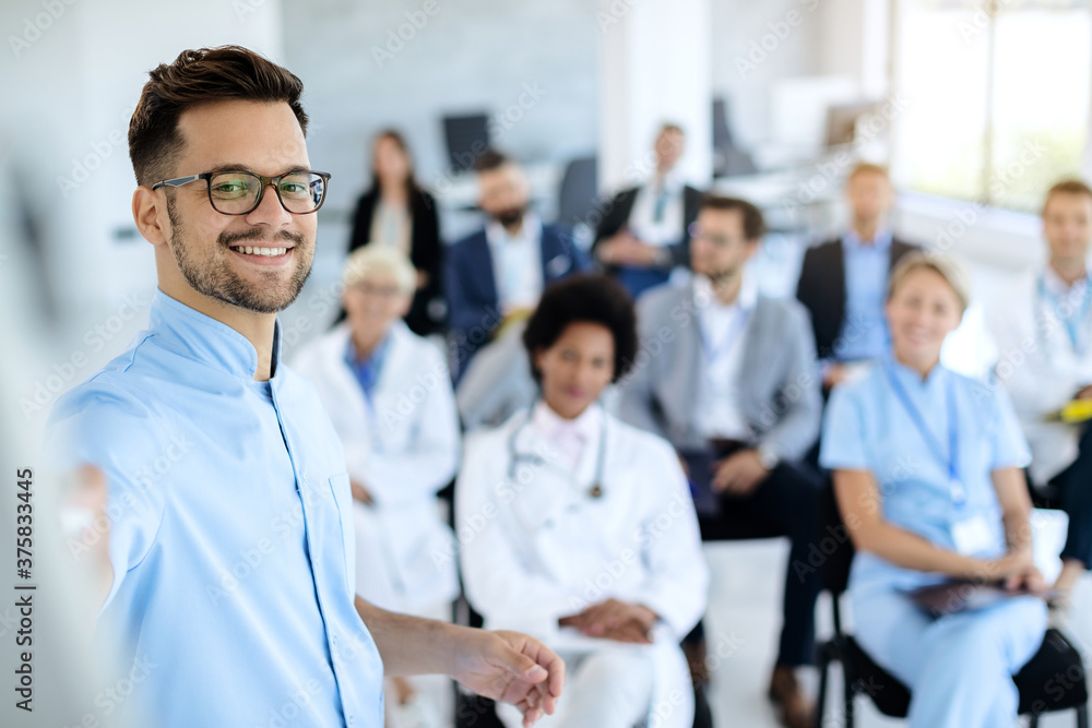 Happy businessman giving a presentation to group of colleagues and doctors. Happy businessman giving a presentation to group of colleagues and doctors.