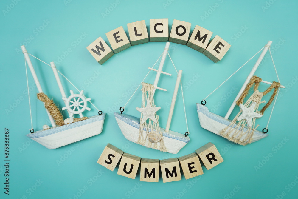 Welcome Summer message alphabet letter with sailboat on blue background