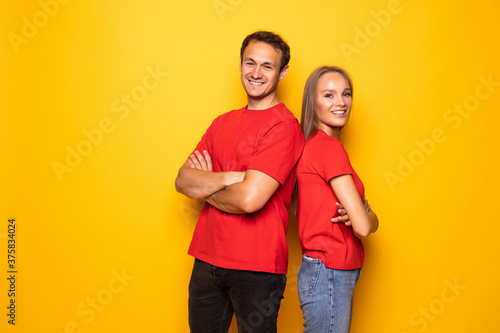 Portrait of cool couple in red shirts looking at camera isolated on yellow background. © F8  \ Suport Ukraine