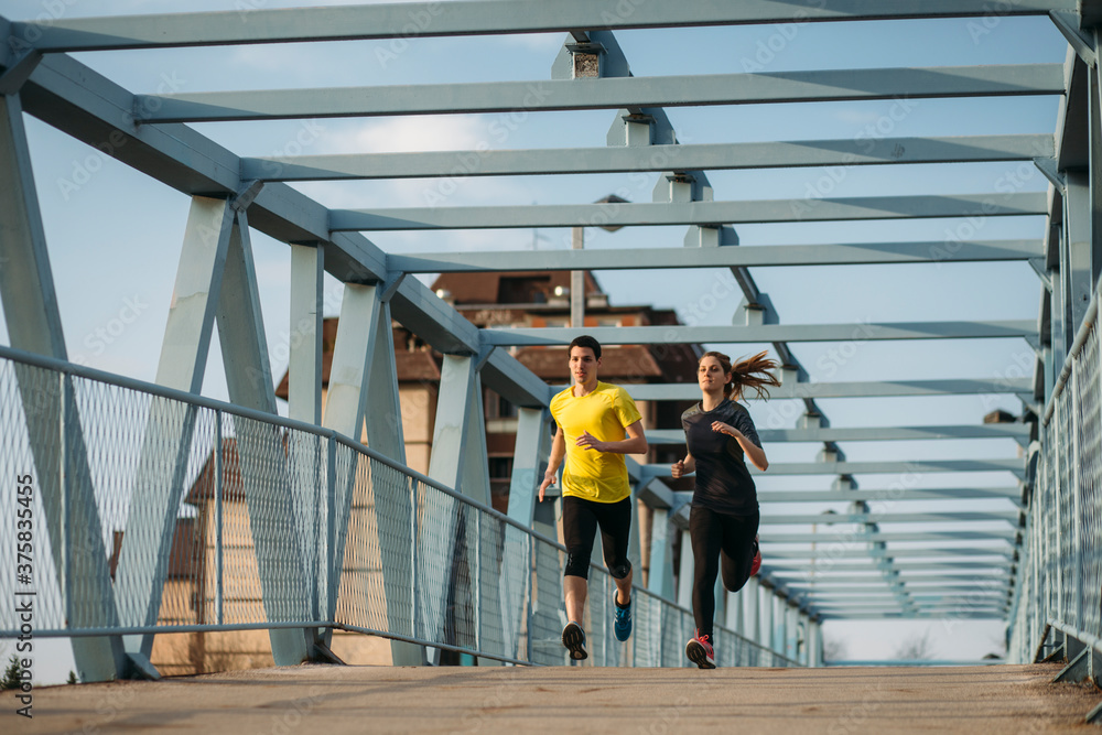 © Marko/Stocksy - Runners couple on the street
