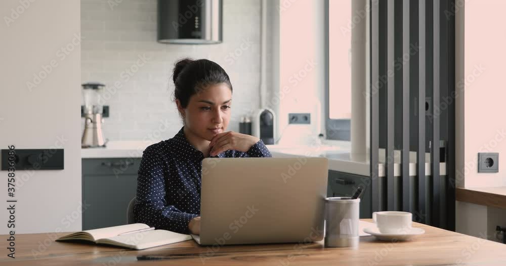 Thoughtful indian businesswoman sit at desk work on laptop faced the challenge lost in thoughts stares out window. Pensive girl looking away think of problem search for solution, inspiration new ideas Thoughtful indian businesswoman sit at desk work on laptop faced the challenge lost in thoughts stares out window. Pensive girl looking away think of problem search for solution, inspiration new ideas