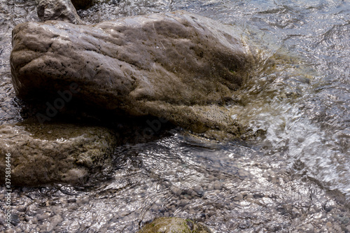 Sea stones in the sea water. Pebbles under water. The view from the top. Nautical background. Clean sea water. Transparent sea.