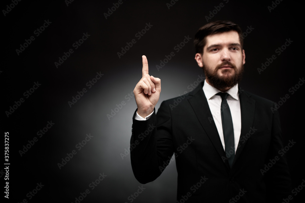 Man in suit pointing his index finger up Man in suit pointing his index finger up