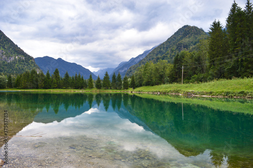 Crystal blue water in little lake with mountains in background, Austrian alps