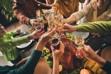 Cropped view of nice attractive cheerful big full family small little kids sitting around served table eating festal meal clinking glasses at modern loft industrial wooden interior house indoors