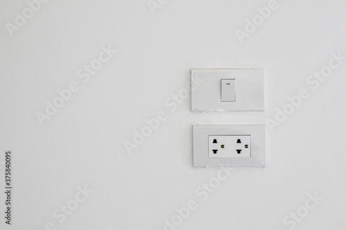 Electrical switches and sockets on white wall background.