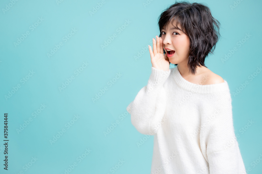 Young woman posing gesture with hands isolated on blue background Young woman posing gesture with hands isolated on blue background