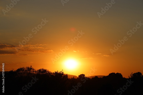 Photography feuerroter Sonnenuntergang hinter einem kleinen Hügel