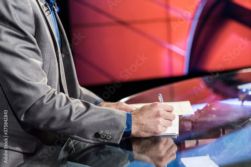 Tv presenter writing down notes before broadcast
