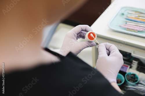 Dental hygienist preparing to apply numbing gel on a patient