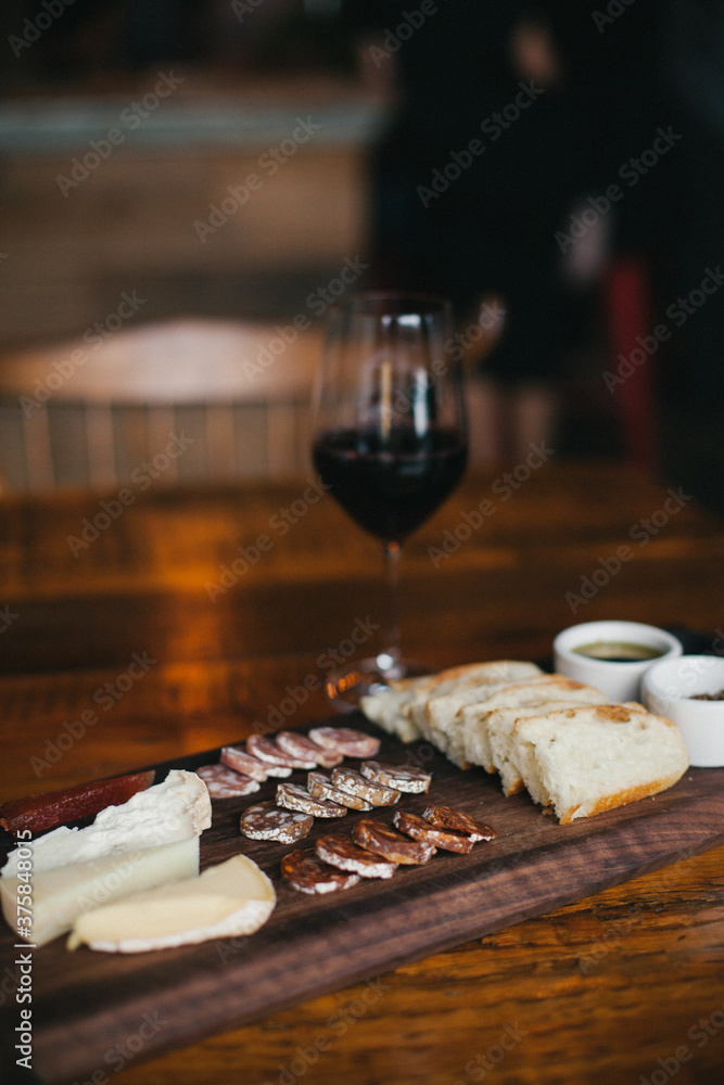 Aeiral view of a charcuterie and cheese board on a table with wine Aeiral view of a charcuterie and cheese board on a table with wine