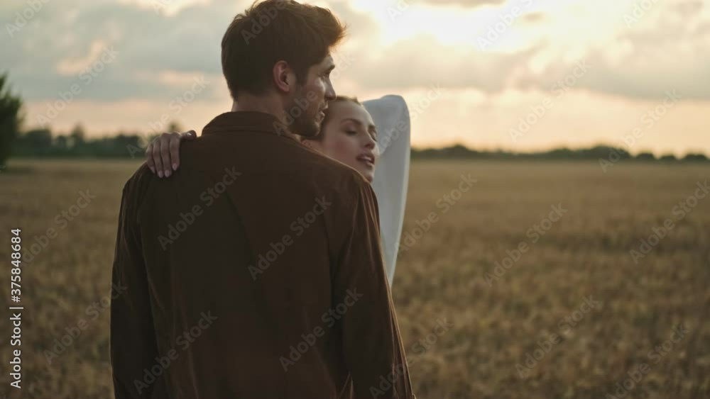Good looking couple man and woman are talking while walking in the field Good looking couple man and woman are talking while walking in the field
