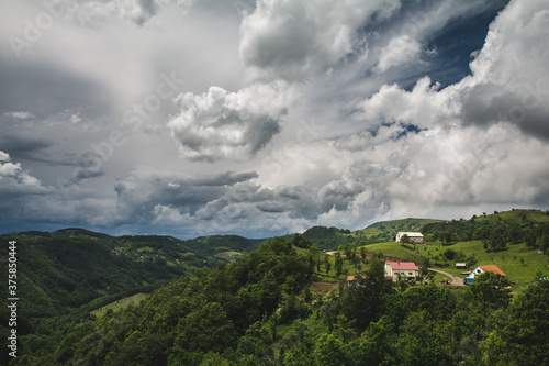 Small farm in a mountain village under the cloudy sky in western Serbia
