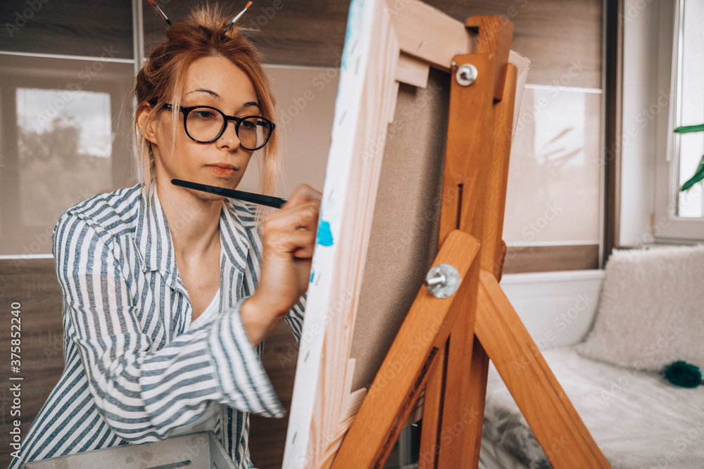 Beautiful artist woman painting in her room. Beautiful artist woman painting in her room.