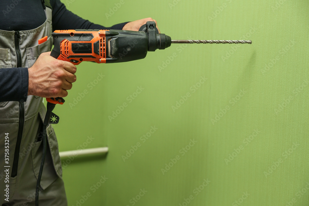 man's hand holds hammer drill man's hand holds hammer drill