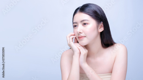 Asian woman beauty shot with half naked isolated on blue background with clean fresh skin.