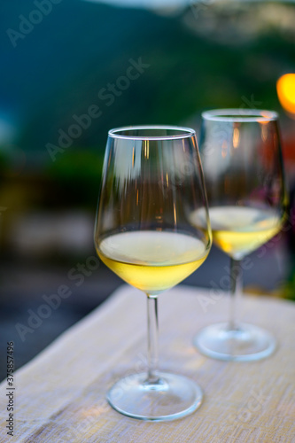 Two glasses of cold dry white wine served outdoor in cafe at night in Italy