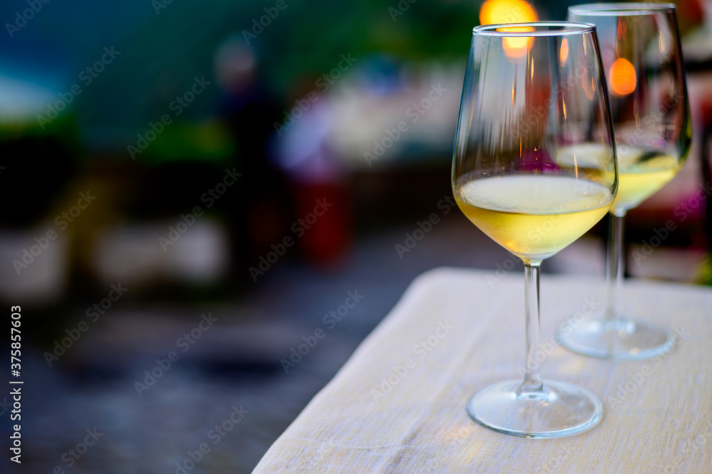 Fototapeta premium Two glasses of cold dry white wine served outdoor in cafe at night in Italy