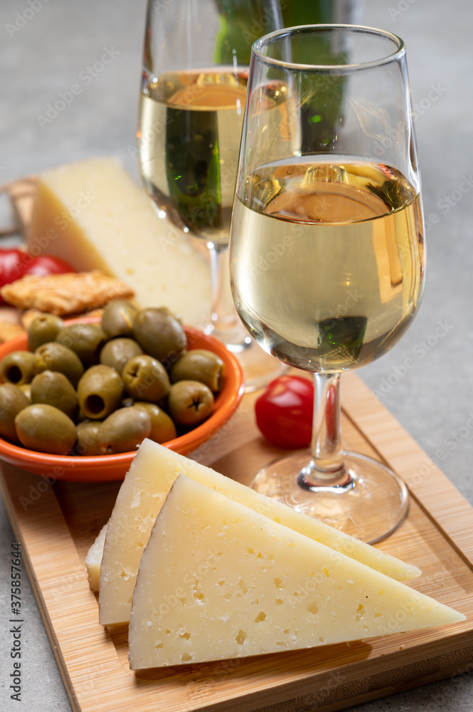 Glasses of dry fino sherry wine served with spanish tapas, manchego cheese, green olives, cheese crackers Glasses of dry fino sherry wine served with spanish tapas, manchego cheese, green olives, cheese crackers