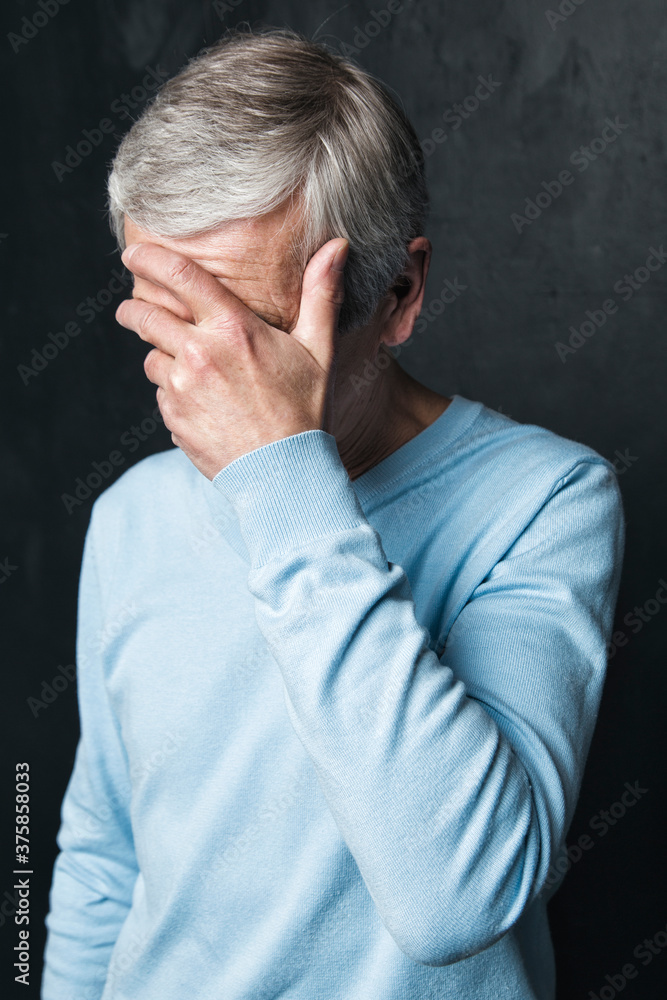 Anonymous sad old man covering face with palm Anonymous sad old man covering face with palm