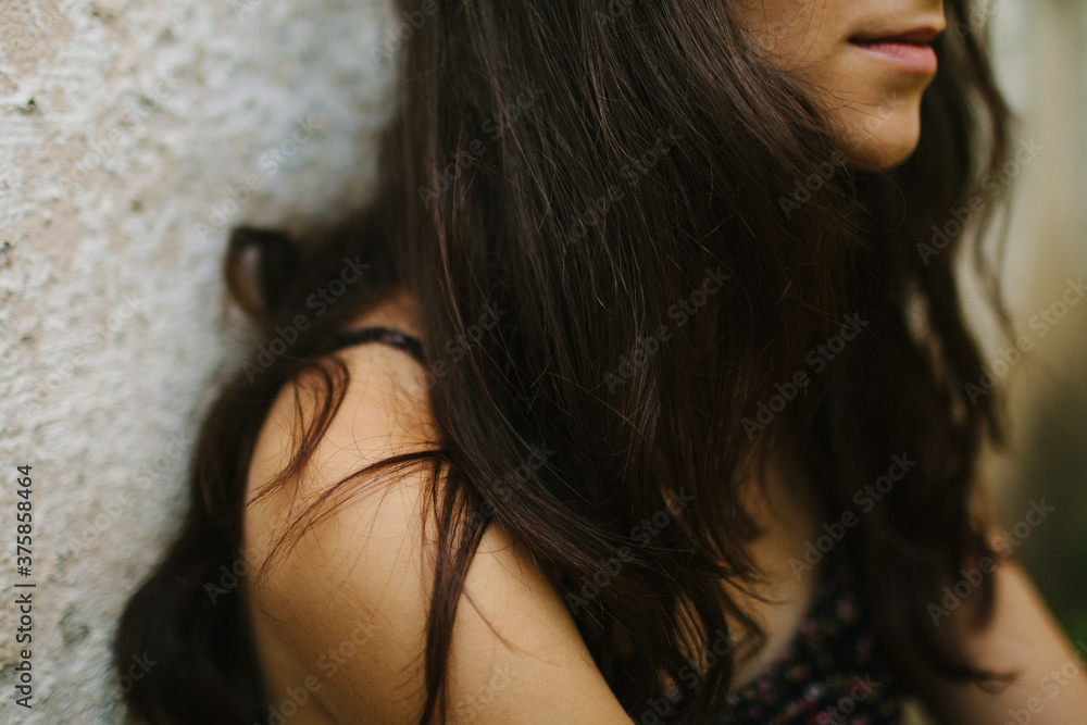 Detail of young woman by concrete wall Detail of young woman by concrete wall