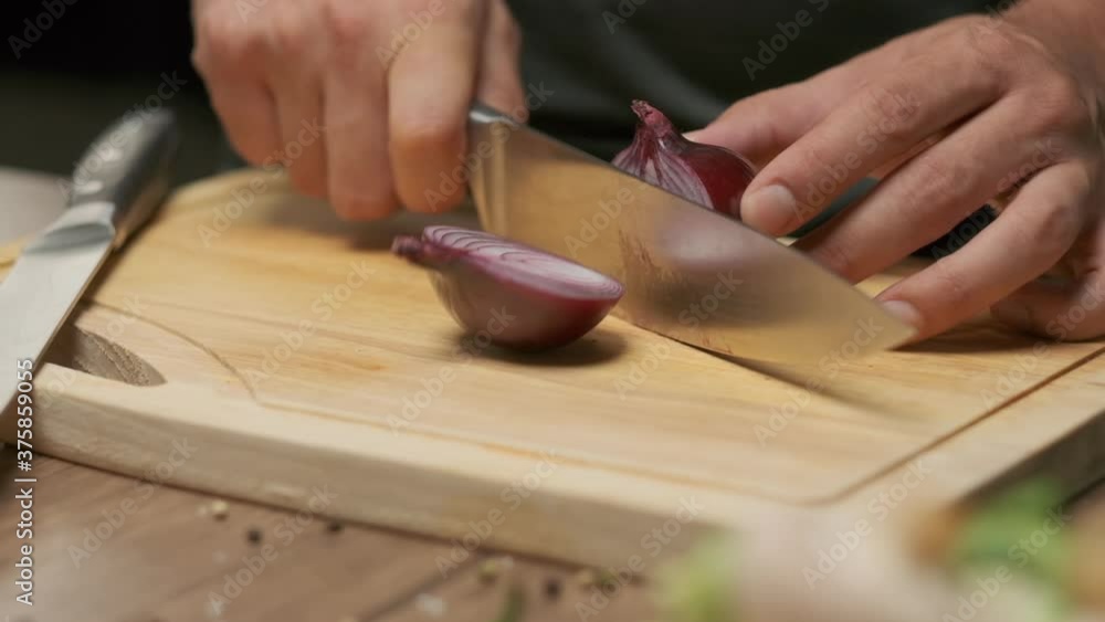 Professional chef prepares and cuts red onion. Close up slow motion Professional chef prepares and cuts red onion. Close up slow motion