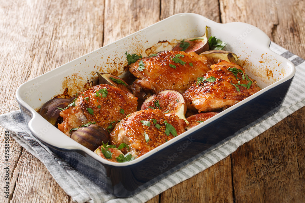 Rustic style chicken thighs baked with figs close-up in a baking dish on the table. horizontal Rustic style chicken thighs baked with figs close-up in a baking dish on the table. horizontal