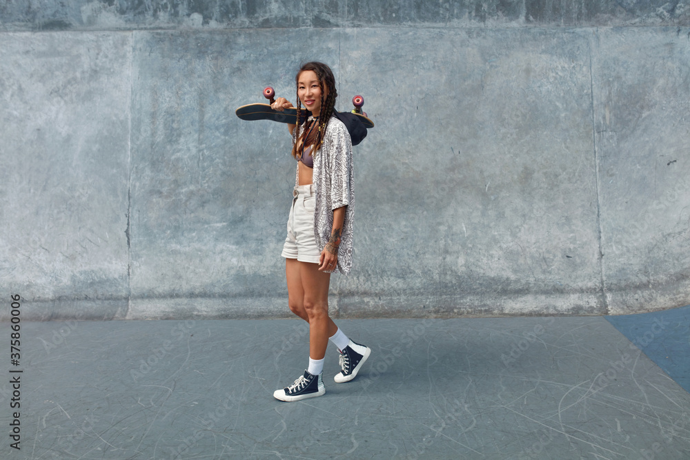 Subculture. Skater Girl With Skateboard At Skatepark Full-Length Portrait.  Asian Teenagers In Urban Outfit With Modern Sport Equipment Against  Concrete Wall. Active Teens In City Lifestyle. Photos | Adobe Stock
